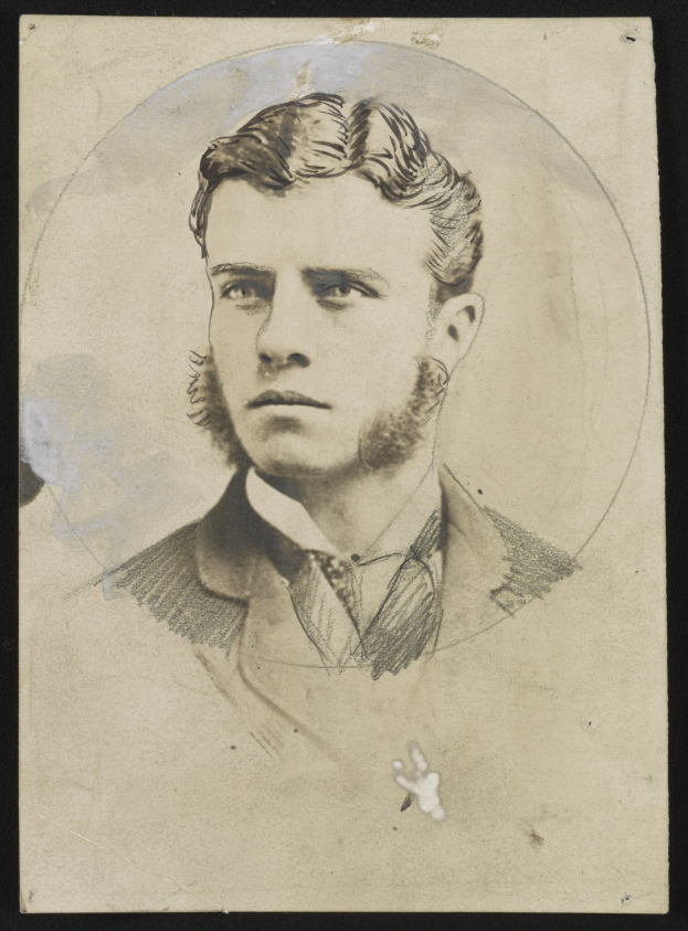 Schwarzes und weißes Porträt eines bärtigen Mannes mit ernstem Gesichtsausdruck, der direkt in die Kamera schaut.