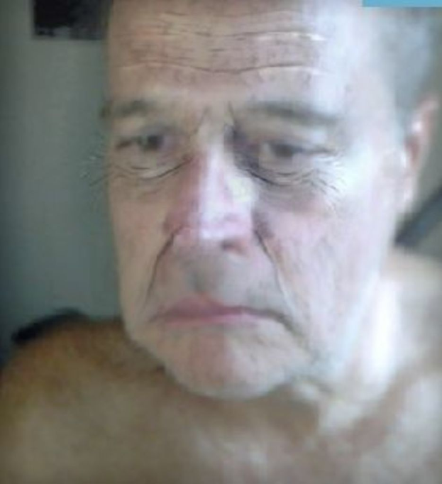 Ein unscharfer Schnappschuss, der nur das Gesicht eines alten Mannes zeigt.