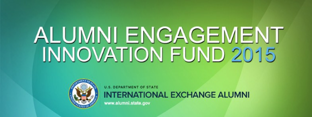 Grüner Hintergrund mit zentralem weißem Text, der "Alumni Engagement Innovation Fund 2015" liest, und einem blauen kreisförmigen Logo mit weißer Umrandung und einem weißen Stern in der Mitte.