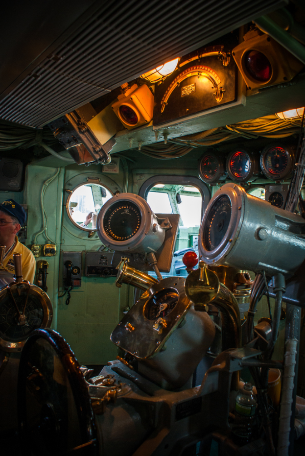 Das Innere eines Zuges mit Sitzen und verschiedenen Gegenständen zu sehen; eine Person in einem gelben T-Shirt steht auf der linken Seite des Bildes.