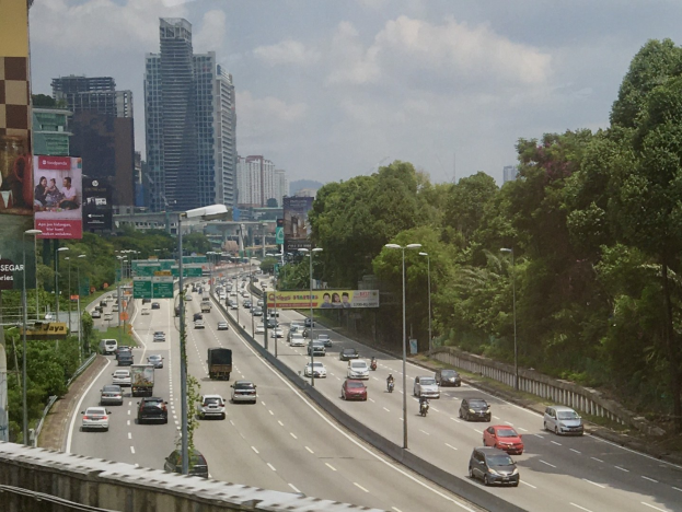 Schwarz-weiß-Postkarte vom Dresdner Hauptbahnhof mit einer belebten Straße, Fahrzeugen, Passanten, Bäumen, Gebäuden und einem bewölkten Himmel.