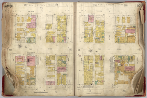 Ein aufgeschlagenes Buch mit einer detaillierten Stadtkarte, die Straßen, Gebäude und Sehenswürdigkeiten zeigt, wahrscheinlich ein Stadtführer.