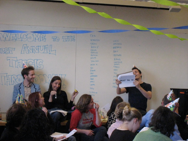 Eine Gruppe von Menschen feiert ihren ersten jährlichen Thesenvorwurf, mit Bändern auf dem Dach und einigen Personen mit Kappen.