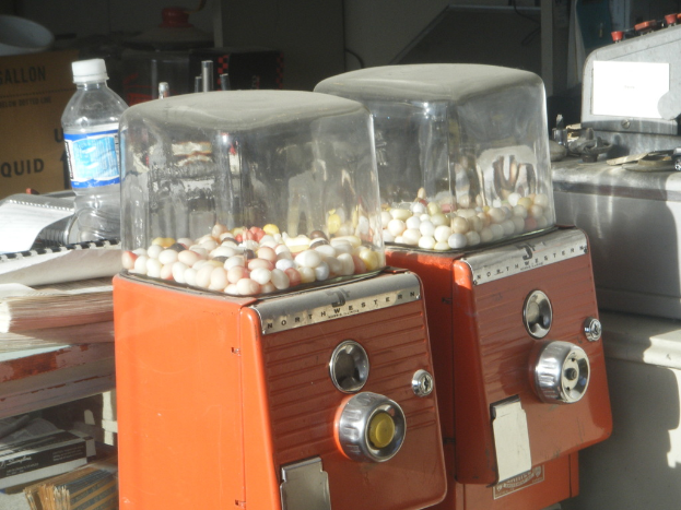 Zwei Maschinen mit Bonbons im Vordergrund, mit B√ľchern und einer Wasserflasche im Hintergrund.