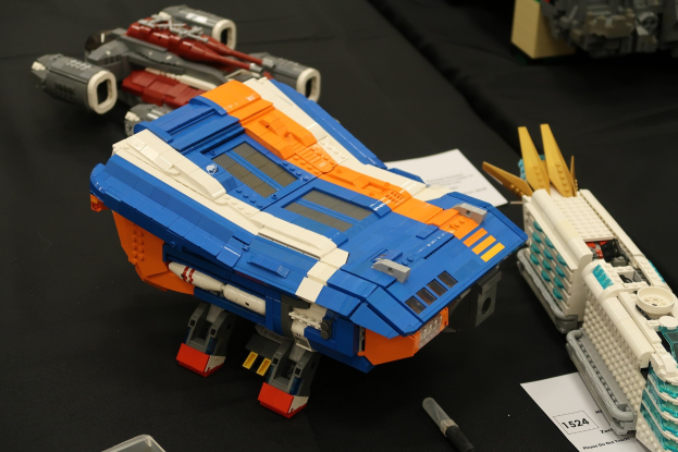 Ein Tisch, der mit verschiedenen Lego-Spielzeugen bedeckt ist, darunter ein Stift, Papier und andere kleine Gegenstände.