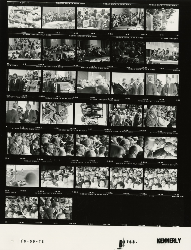 Schwarzes und weißes Foto einer vielseitigen Menge von Menschen, die um einen Fernseher versammelt sind und in die Kamera schauen, mit Text unten.