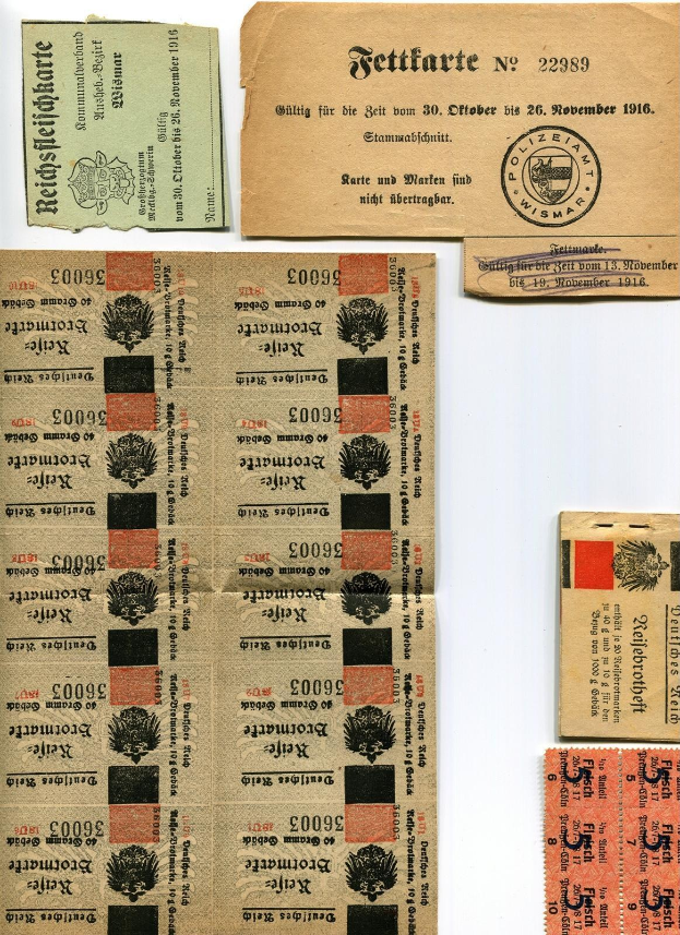 Sammlung alter deutscher Fahrkarten und Marken auf einem weißen Hintergrund, mit abgenutztem Papier und gedrucktem Text und Zahlen.