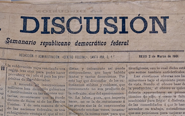Eine vergilbte, leicht zerknitterte Zeitung mit der schwarzen Schrift 'Diskussion' darauf, die die Schlagzeile 'Semanario Repúblicano Democrático Federal' trägt.