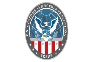 Logo der U.S. Zoll- und Grenzschutzbehörde Handel - Ein blauer Kreis mit einem weißen Stern, einer weißen Taube mit ausgebreiteten Flügeln und dem Text "U.S." darüber, alles auf einem weißen Rand.