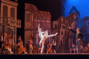 Zwei Tänzer performen auf einer Bühne im Royal Opera House in London, mit einem Publikum, das im Vordergrund sitzt und steht.