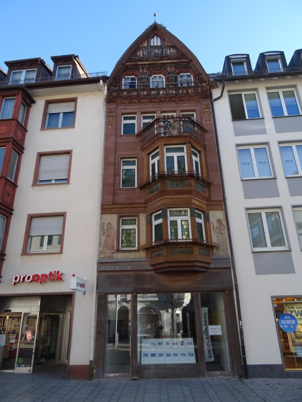 Gewerbliches Eigentum zum Verkauf mit vielen Fenstern an einer Straße in Heidelberg, Deutschland, unter einem klaren blauen Himmel.