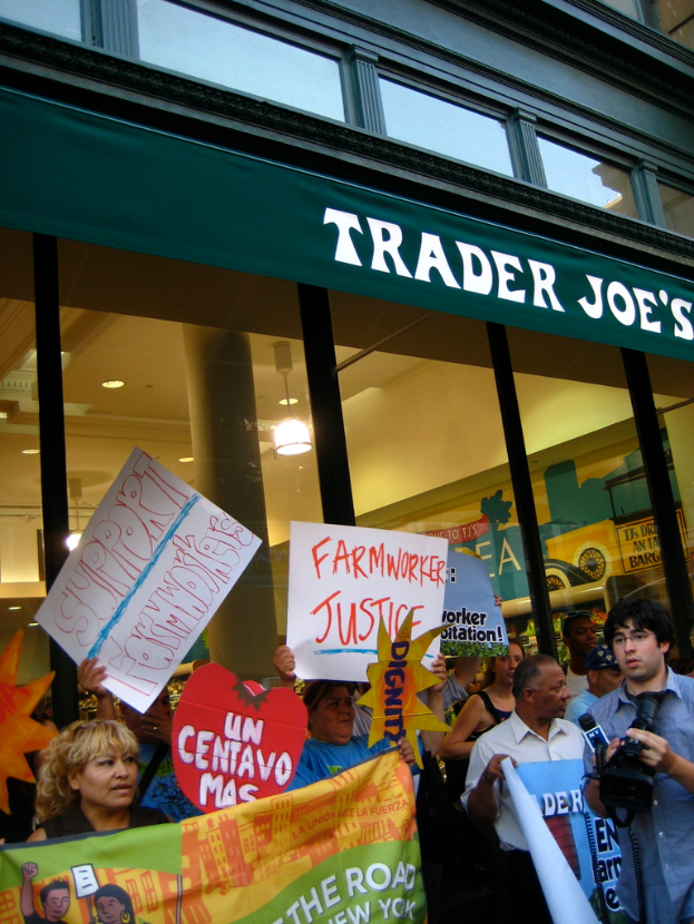 Eine Gruppe von Menschen steht vor einem Geschäft und h√∂lt Schilder und Plakate.