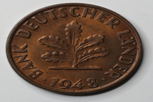 Eine Münze mit den Worten "Bank Deutscher Land" darauf vor einem weißen Hintergrund.