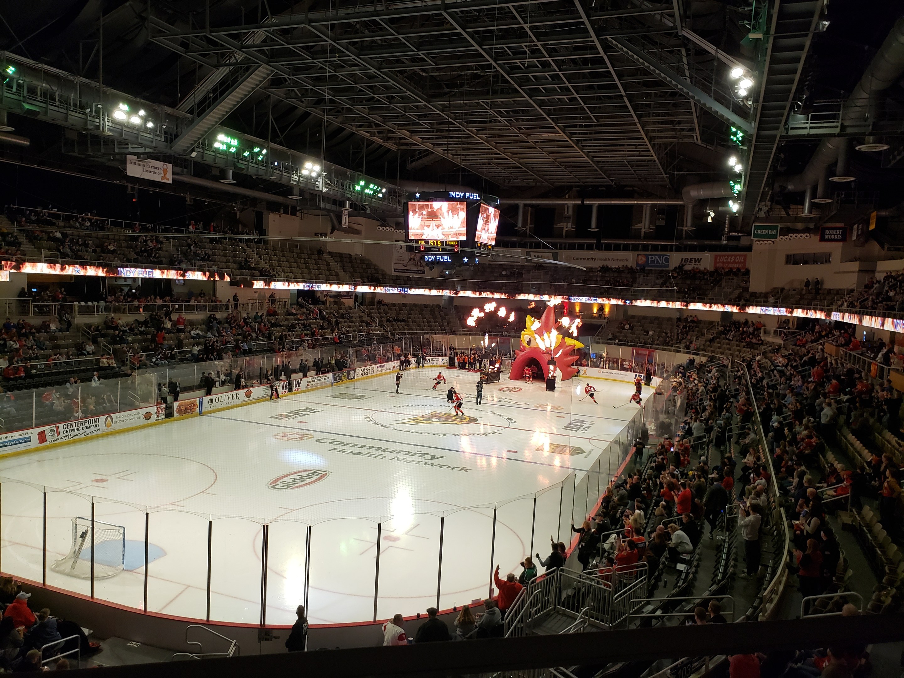 Eishockeyspiel in einer großen Arena mit Zuschauern, die Eisfläche von einem Zaun umgeben, Banner, Deckenbeleuchtung und zwei Bildschirme; die Location ist die Nationwide Arena.