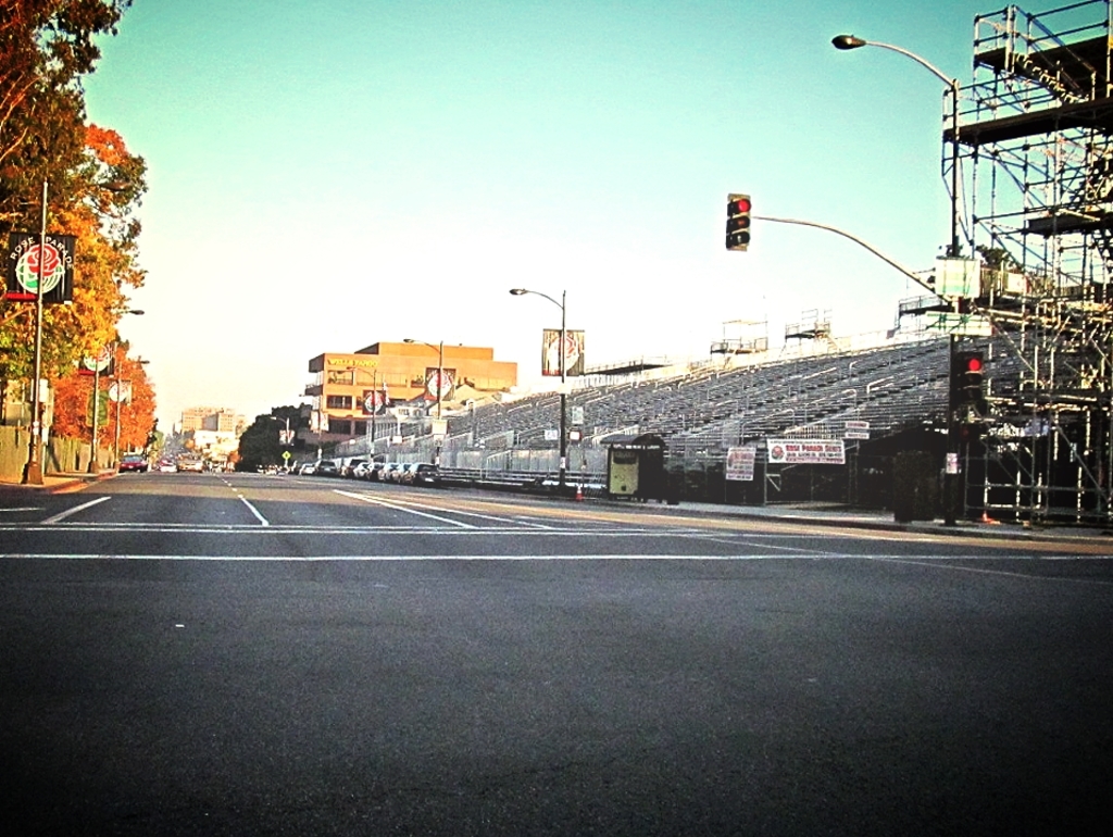 Eine Straße mit einer Verkehrsampel und Gerät auf der rechten Seite, Warnschilder und mehrere Fahrzeuge auf der linken Seite und Bäume im Hintergrund.