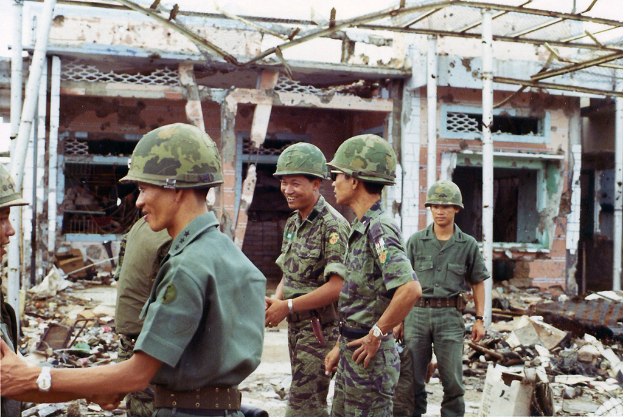 Ein demoliertes Haus mit einigen Soldaten in der NÃ¤he.