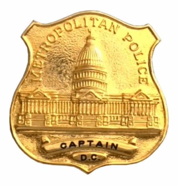 Goldenes Metropolitan Police Captain Abzeichen mit "Metropolitan Police Captain" Text auf einem weißen Hintergrund.