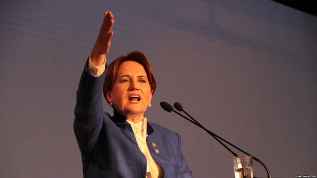 Eine Frau steht an einem Podium mit zwei Mikrofonen und einem Glas Wasser und spricht vor einem Bildschirm, wahrscheinlich zu einer Regierungsentscheidung, Frauenrechte zu verbieten.