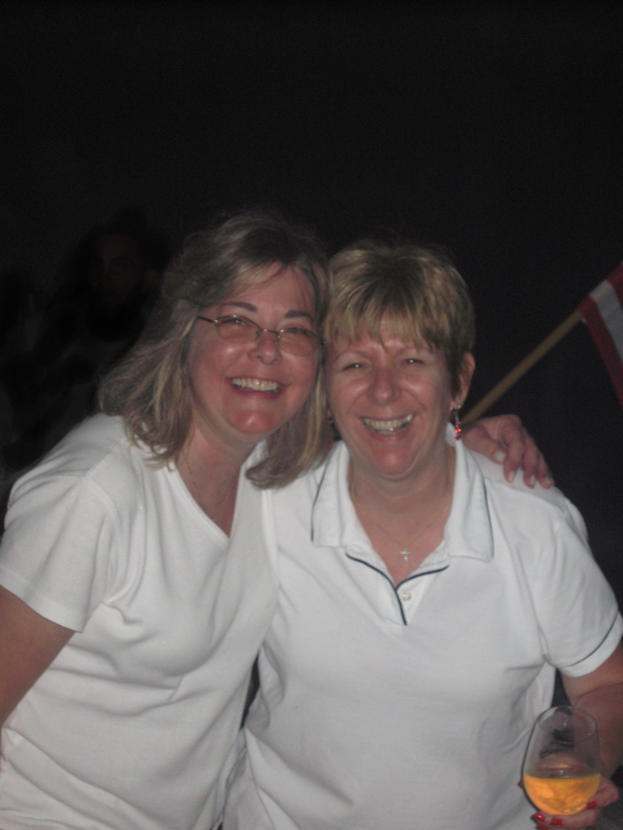 Zwei Männer stehen und lächeln, jeder hält ein Weinglas.