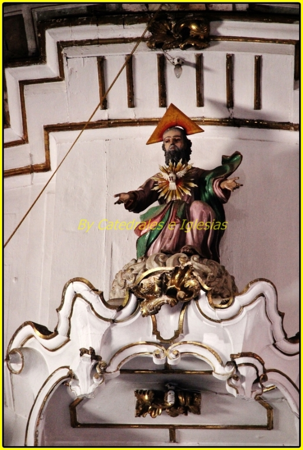 Eine Skulptur und eine Wand mit einem Kabel links und oben sowie einer Birne an der Wand oben.