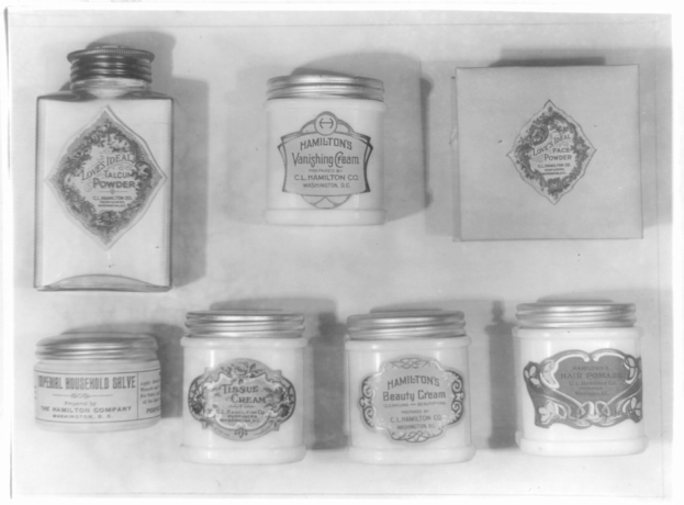 Schwarzes und weißes Foto eines Regals mit ordentlich angeordneten Cremegläsern, die jeweils mit verschiedenen Typen beschriftet sind.