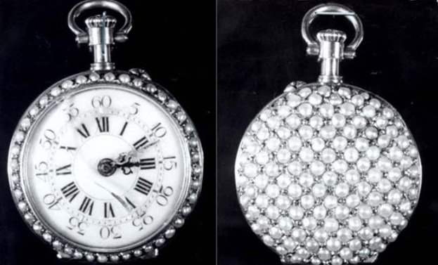Eine silberne Taschenuhr mit Diamanten, die in einem runden Gehäuse mit römischen Ziffern auf einem schwarzen Hintergrund funkeln.