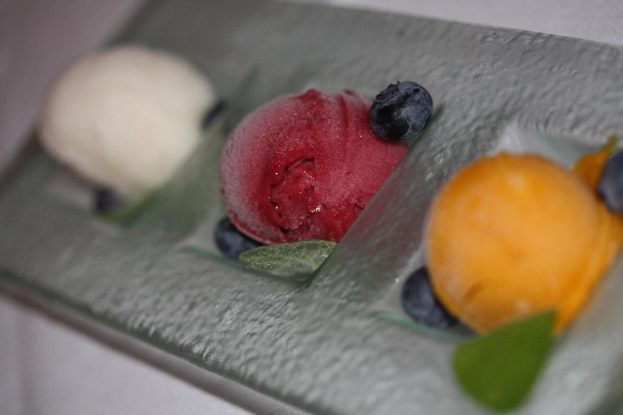 Blumen und Früchte werden auf einer Oberfläche präsentiert.