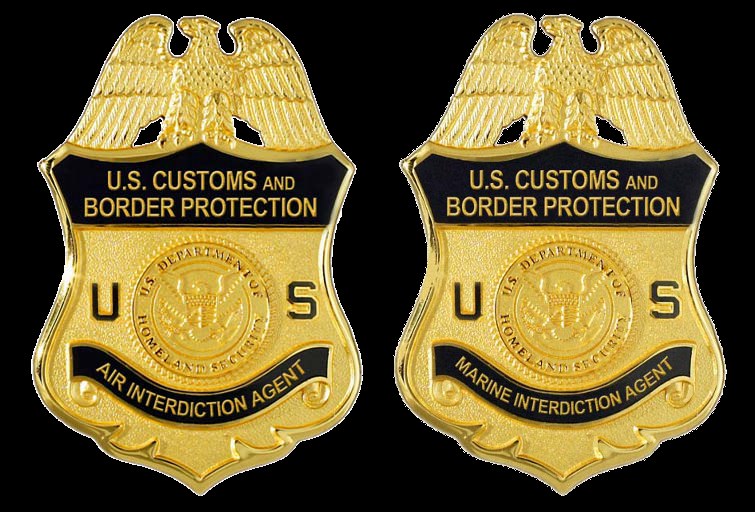 Zwei goldfarbene Abzeichen mit 'U.S. Customs and Border Protection'-Text auf weißem Hintergrund.