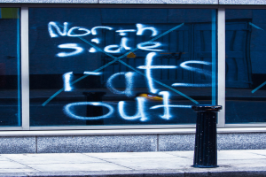 Text auf einem Fenster und einer Absperrstange auf der Straße.