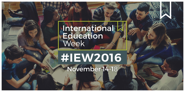 Eine Gruppe von Menschen sitzt auf einer Couch, einige halten Bücher und Stifte, mit dem Text "International Education Week IEW 2016" in der Mitte, die in ein Gespräch vertieft sind.