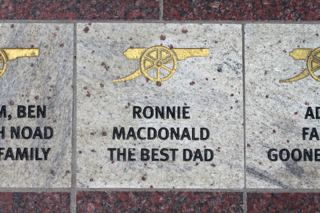 Ein historisches Schild mit Symbolen und Text in der Mitte des Bildes.