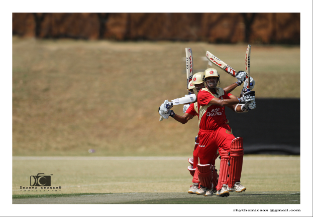 Eine Gruppe von Spielern, die auf einem Feld stehen, alle die gleiche Uniform tragen und Schl√§ger halten, mit einer Wand im Hintergrund und einem Wasserzeichen in der linken unteren Ecke.