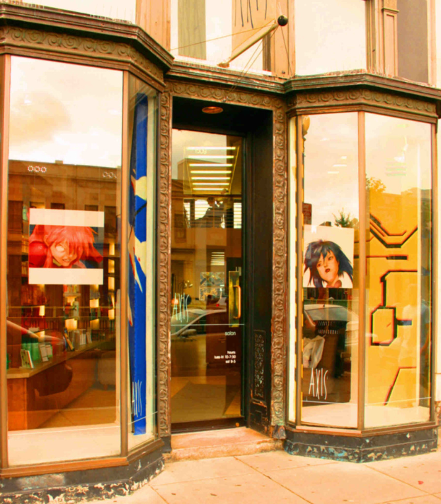 Ein Bild eines Innenraums mit einem Tisch, Wandplakaten und Kosmetikartikeln auf der linken Seite.