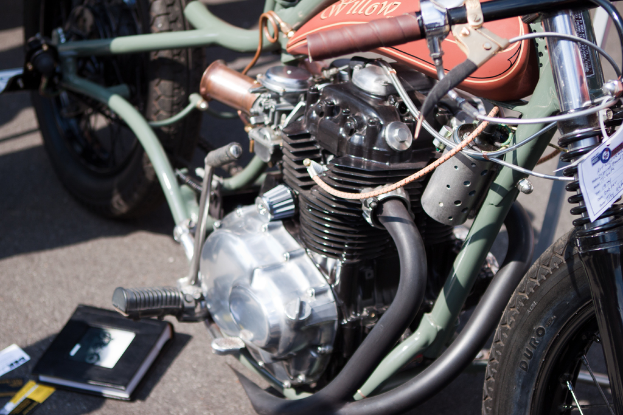 Mehrere Motorräder auf einer Straße geparkt mit einem Buch auf einem der Sitze.