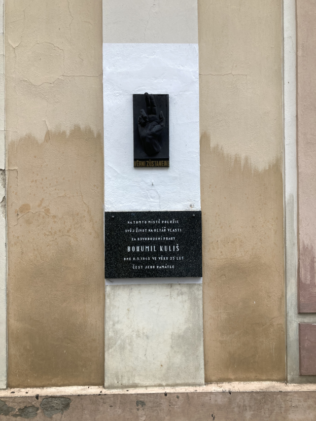 Eine schwarze Tafel an einem Gebäude mit einer Hand darauf, die Holocaust-Opfer gedenkt.