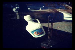 Ein Auto steht auf der Straße neben einer Kette und einer Flasche.