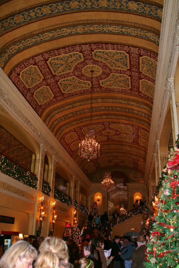 Eine Gruppe von Menschen, die zwischen Pflanzen mit Lampen an der Decke steht.
